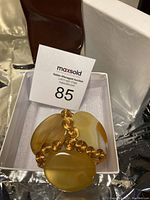 Handmade copper wire bracelet featuring multiple yellow agate stones in a box, shown from front angle.