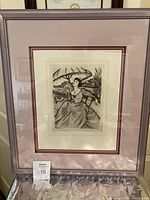 Framed etching art piece showing the full framing and matting with glass reflection