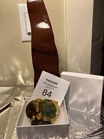 Front view of the handcrafted copper wire bracelet with three green agate stones, set in a white cushioned display box.