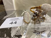 Photo showing adjustable handmade copper wire bracelet with white veined agate and flower-inspired silver-toned accents plus matching copper wire ring with white agate stone on silver pouch