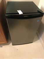 Front view of Sunbeam compact refrigerator with stainless steel door and black top.