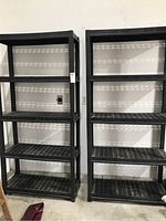 Two black plastic shelving units positioned side by side with four shelves each.
