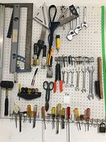 Wide shot showing all assorted hand tools including wrenches, screwdrivers, putty knives, scissors, hex keys and mallet hung on pegboard