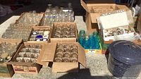 Overhead shot of several boxes filled with clear canning jars and a blue speckled enamel pot