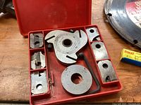 bench saw molding head cutter set in red case including multiple cutter heads, rings, and hex key