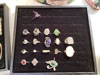 Sterling silver rings and various rings organized on black felt display tray