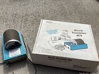 Blue Lortone rotary rock tumbler with original box featuring kit contents listing and instructions.