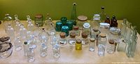 Wide shot of all glass bottles and jars on table showing variety and arrangement