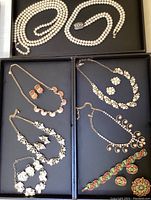 Full display of all jewelry pieces including pearl necklace and various necklace and earring sets