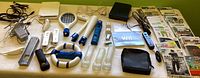 Photo of various Nintendo Wii controllers, protective sleeves, cords, and additional gaming attachments arranged on a table.