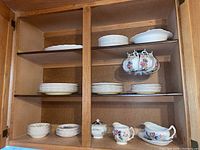 Photo of the full cabinet shelf displaying cups, saucers, plates, serving bowl, and gravy boat.