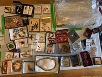 Overview of multiple boxes and loose pieces including bracelets, necklaces, brooches and earrings