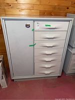 Front view of white dresser showing six drawers on right and a left-side cabinet door