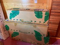 Three cardboard boxes stacked, printed Sterling’s Palms graphics