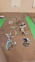 Group of 10 sterling silver rings with marcasite, amethyst, garnet, and cubic zirconia stones.