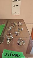 10 sterling silver rings with assorted stone/gemstone and marcasite accents displayed on mirrored surface