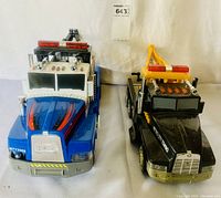 Front view showing the front grills, lights and colors of both tow truck toys side by side
