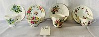Four matching pairs of English bone china tea cups and saucers with various floral patterns displayed in a single row