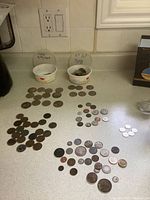 Overview of all coins arranged on countertop with Canadian and US coin bowls