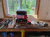 Workbench with various tools and model tractor, crafting supplies and measuring tapes