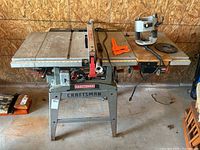 Full view of Craftsman table saw on metal stand with attached Skil router on the right side