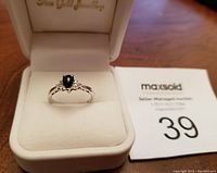 Ring displayed in open white jewelry box, front view