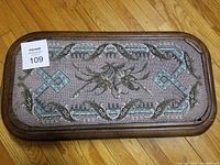 Top view showing full beaded design and wood frame of the foot stool.