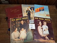Five Royal memorabilia publications displayed, including 'Our Young Prince' magazines, Thanksgiving book, Royal Tour 1951 publication and red scrapbook