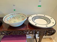 Photo showing both bowls side by side on a carved wooden table.