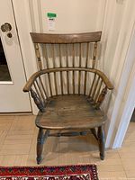 Front view of wooden Queen Anne Windsor style chair with spindle back and curved armrests