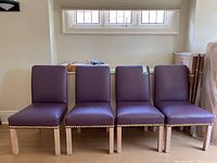 Four chairs in a row under a window, showing full set from the front