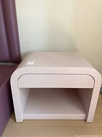 Front view of pink nightstand showing open shelf and drawer front