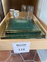 Stack of square greenish glass plates with gold decorative geometric and floral trim
