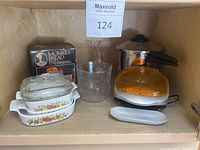 Photo showing all kitchen miscellaneous items including Pyrex dishes, George Foreman grill, vase, glass bowl, monkey bread pan, and pot.