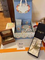 Full lot from a distance showing Claire Murray spa gift box, music box, bookmark box, placemat