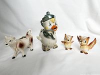 Group view of all four ceramic items: duck teapot, cow creamer, and two owl salt and pepper shakers.