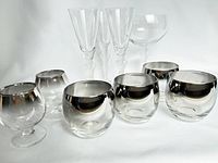 Group photo of four silver ombre lowball glasses and two matching cognac glasses with silver rims and clear glass bodies.