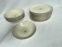 Stack of 5 shallow bowls, 1 smaller shallow bowl in front, and a stack of 11 side plates showing the Modern Stars atomic design