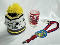 Photo of Snoopy knit beanie, Peanuts glass, and Ninja Turtles suspenders together