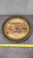 Front view of the Royal Doulton plate showing the full scene titled 'The Battle' with measuring tape for scale.