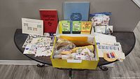 Overview of the entire collection spread on a table showing boxed stamps, albums, books and packets