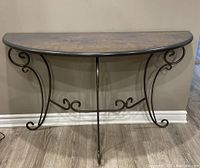 Front view of the half moon entrance table showing wooden top and wrought iron legs with scrolled designs.