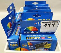 Photo showing eight sealed Konica Film-In single-use cameras in original blue boxes with flash, stacked together.