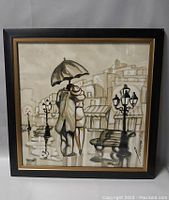 Framed painting showing couple under umbrella on a rainy evening street