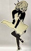 Front view of the Marilyn Monroe shaped clock showing the black and off-white silhouette and clock hands.