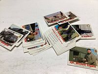 Multiple Armed Forces trading cards spread out on a white surface.