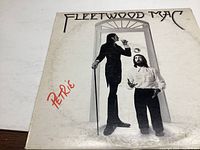 Front cover of Fleetwood Mac Penguin album showing two men, one juggling an apple and the other holding a cane, with album title and band name.