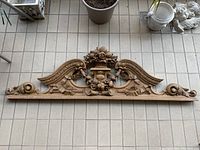 Full front view of entire wood frieze laid on tiled floor