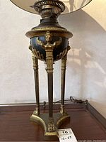 Full view of Empire‐style lamp showing shade, burner assembly, reservoir and tripod base