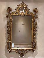 Front view of full mirror showing rectangular shape and ornate carved frame